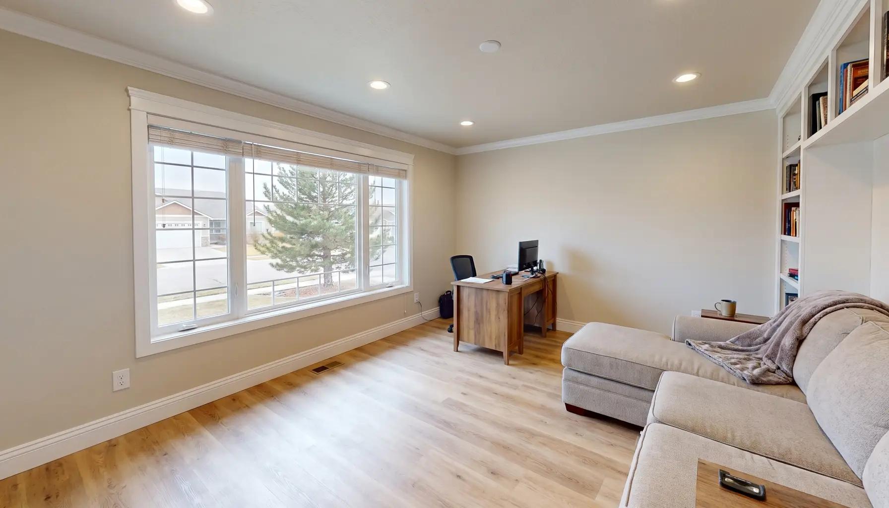 Converted garage finished as a bright bonus room and home office with new windows and luxury vinyl plank flooring in a Boise home